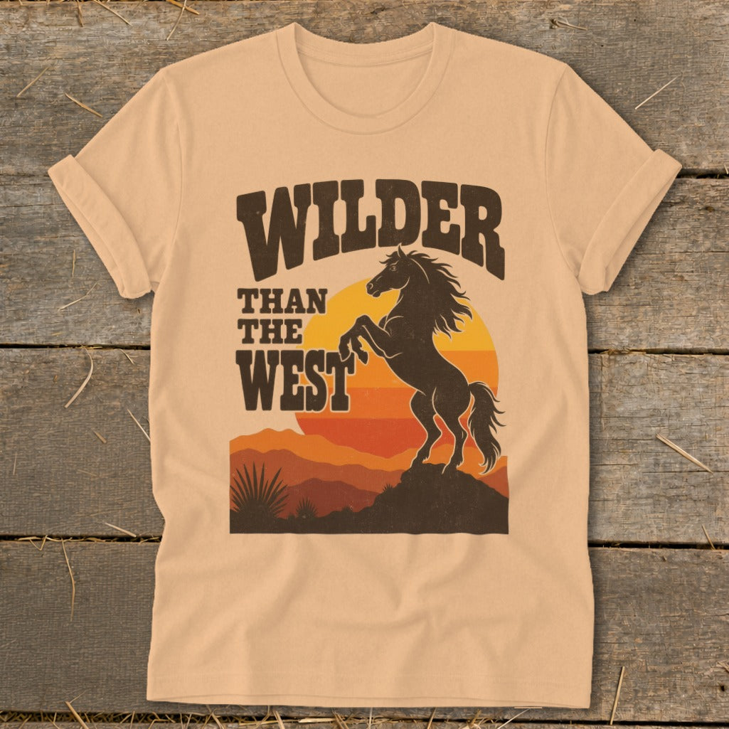 T-shirt graphic: "Wilder Than The West" text above a rearing horse at sunset.