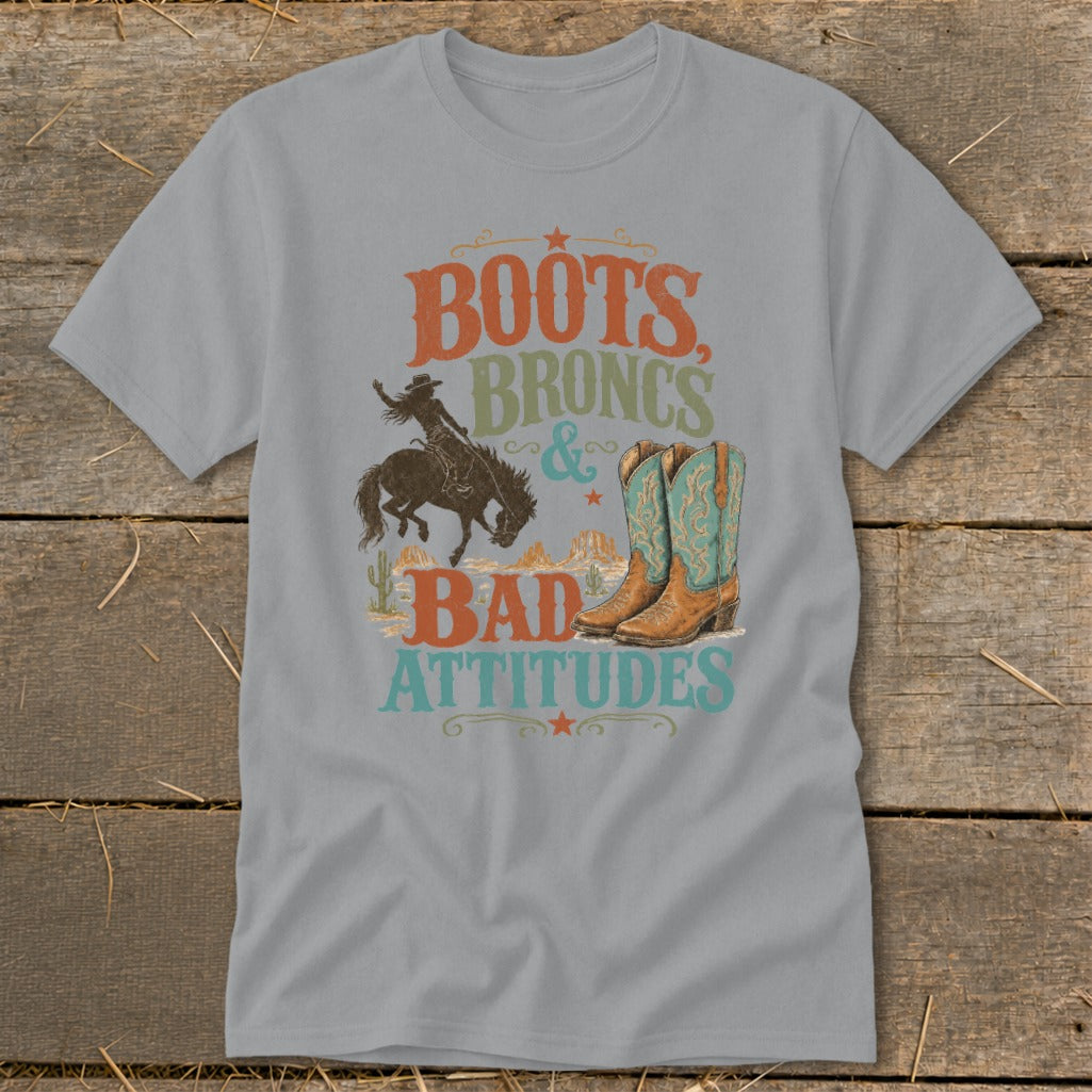 Gray t-shirt with "Boots, Broncs & Bad Attitudes" text, bucking bronco, and cowboy boots graphic.