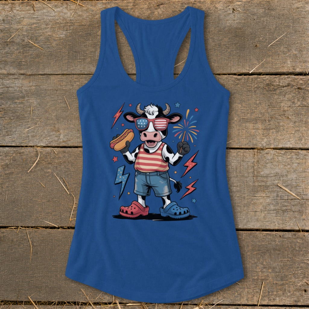 Cartoon cow in patriotic sunglasses holding a hot dog and a sparkler.