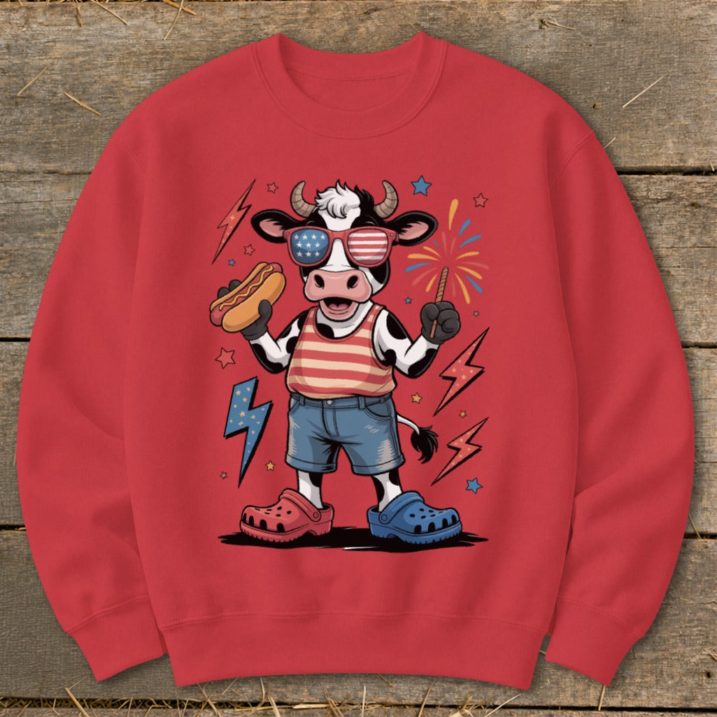 Cartoon cow wearing American flag sunglasses and holding a hot dog.