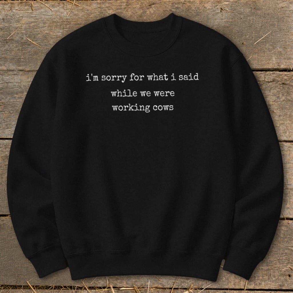 Black crewneck sweatshirt with white text: "i'm sorry for what i said while we were working cows."