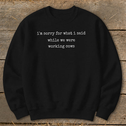 Black crewneck sweatshirt with white text: "i'm sorry for what i said while we were working cows."