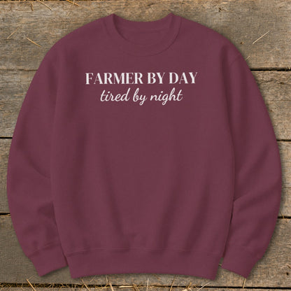 Maroon sweatshirt with white text "FARMER BY DAY tired by night".