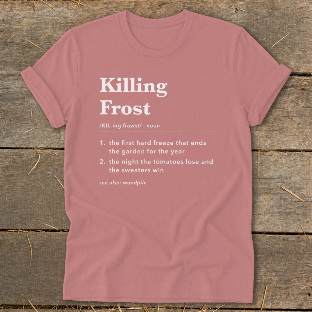 A dusty rose t-shirt features a humorous definition of killing frost printed in white text on the chest.