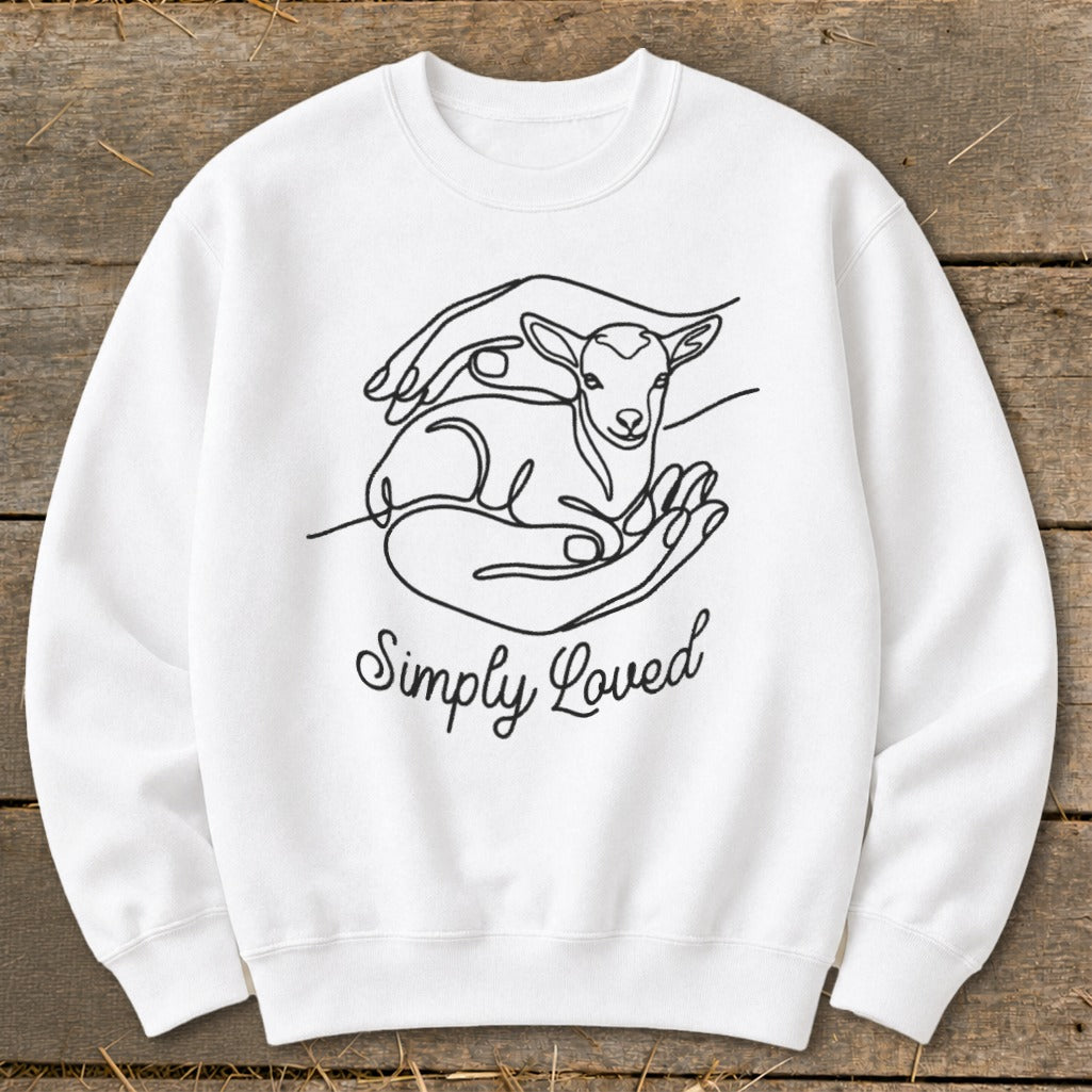 White sweatshirt with line art of hands holding a lamb and text "Simply Loved".