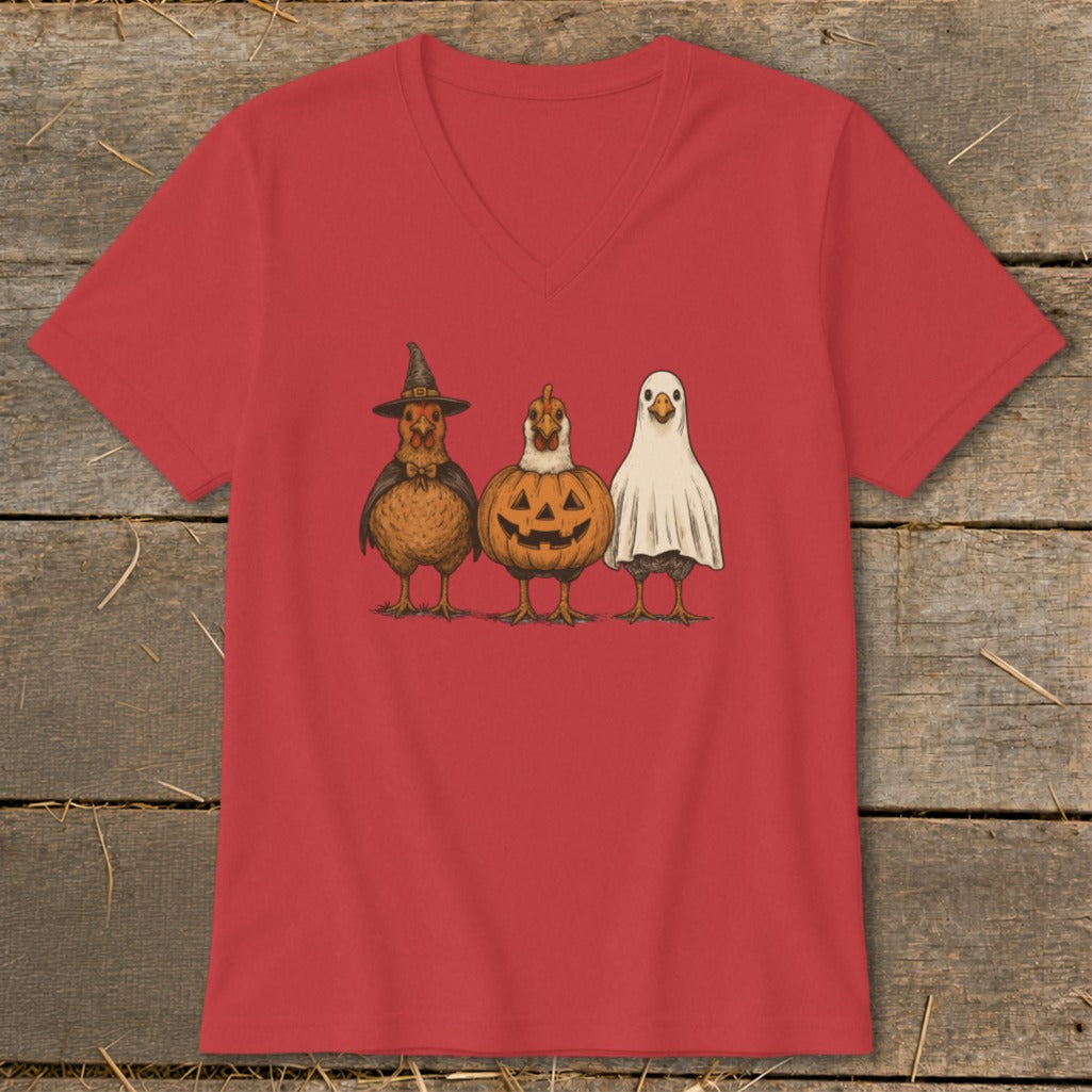 Three chickens dressed as a witch, pumpkin, and ghost on a red t-shirt.
