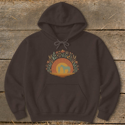 Brown hoodie with a circular graphic of a person and horse at sunset with floral accents.