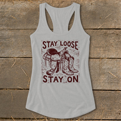 Tank top with "Stay Loose Stay On" text, saddle, and cowboy boots graphic.
