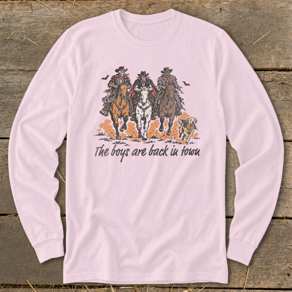 Skeleton, vampire, and zombie cowboys ride horses with a dog; text reads "The boys are back in town."