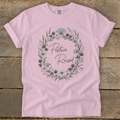 Pink t-shirt with floral wreath graphic and text "Pasture Raised".