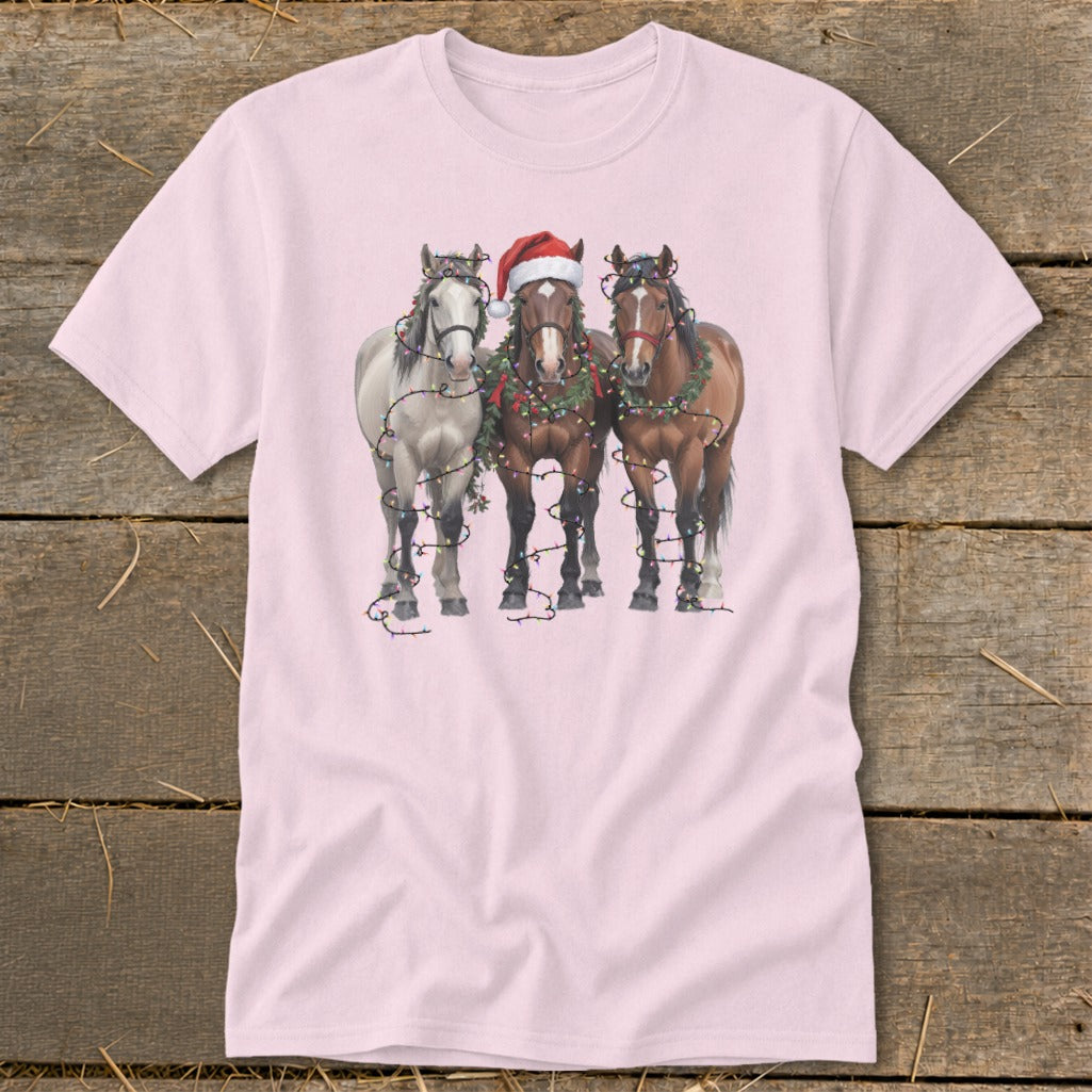 Three horses decorated with Christmas lights and wreaths, one wearing a Santa hat.