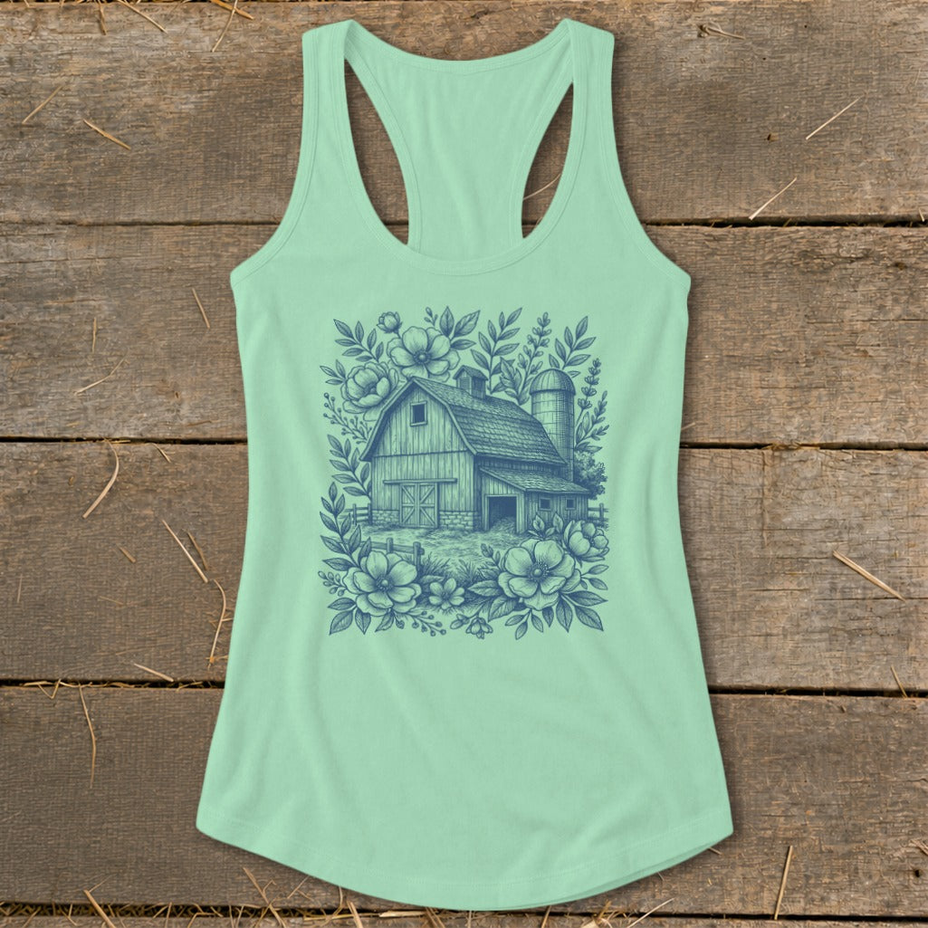 Light green tank top with a blue line drawing of a barn surrounded by flowers.