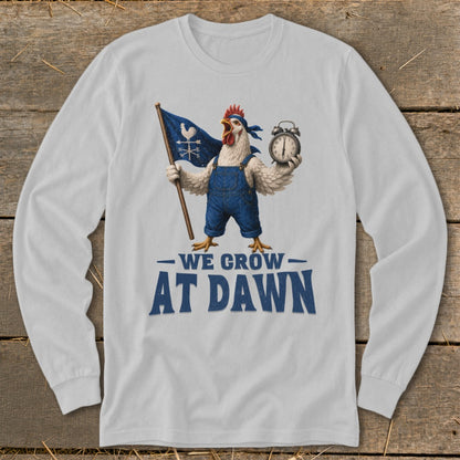 White long-sleeve shirt with a rooster graphic holding a flag and alarm clock, text "WE GROW AT DAWN".