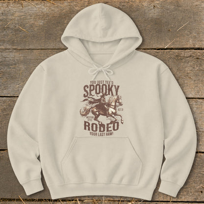 Cream hoodie with "Spooky Rodeo Your Last Haw" graphic featuring a cowboy on a horse.