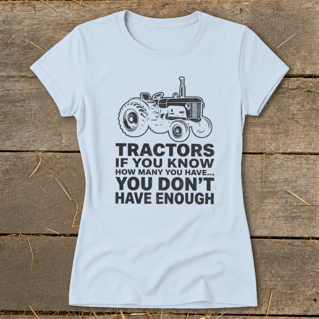 Light blue t-shirt with a black tractor graphic and the text "Tractors if you know how many you have... you don't have enough."