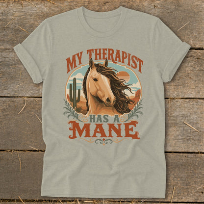 Light tan t-shirt with graphic of horse and text "My therapist has a mane".