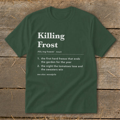 Forest green t-shirt featuring white text that defines killing frost humorously, displayed on rustic wood.