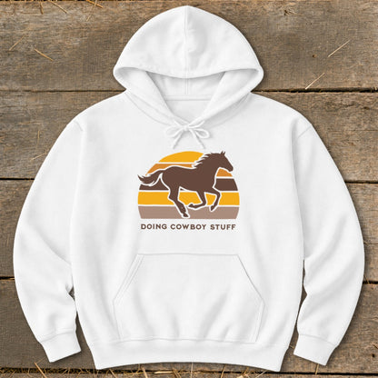 White hoodie with a brown horse silhouette and text "DOING COWBOY STUFF".