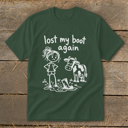 Dark green t-shirt with a white graphic of a sad stick figure, a cow, and a muddy boot.