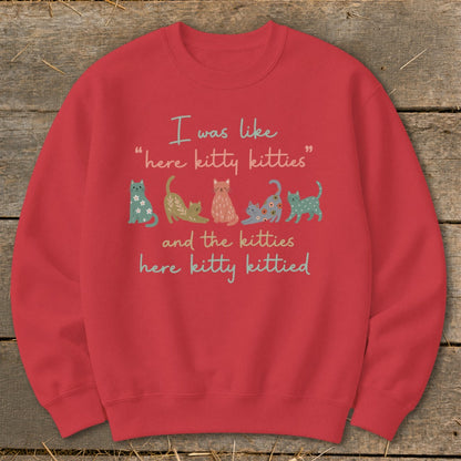Red sweatshirt with "I was like 'here kitty kitties' and the kitties here kitty kittied" and cartoon cats.