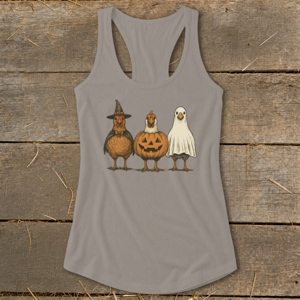 Three chickens dressed in Halloween costumes: witch, jack-o'-lantern, and ghost.