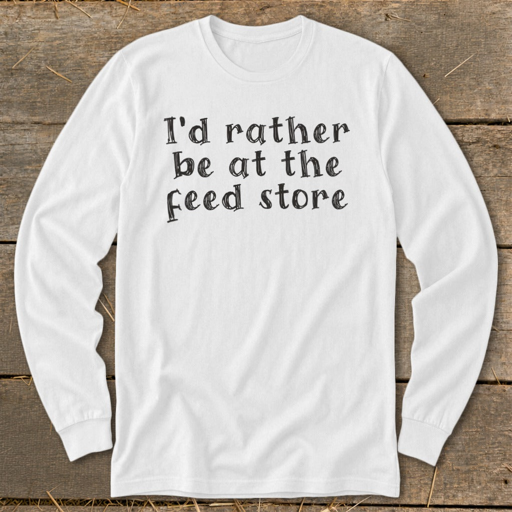 White long-sleeve shirt with black text "I'd rather be at the feed store".