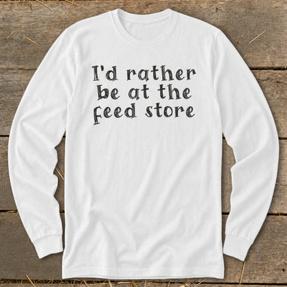 White long-sleeve shirt with black text "I'd rather be at the feed store".