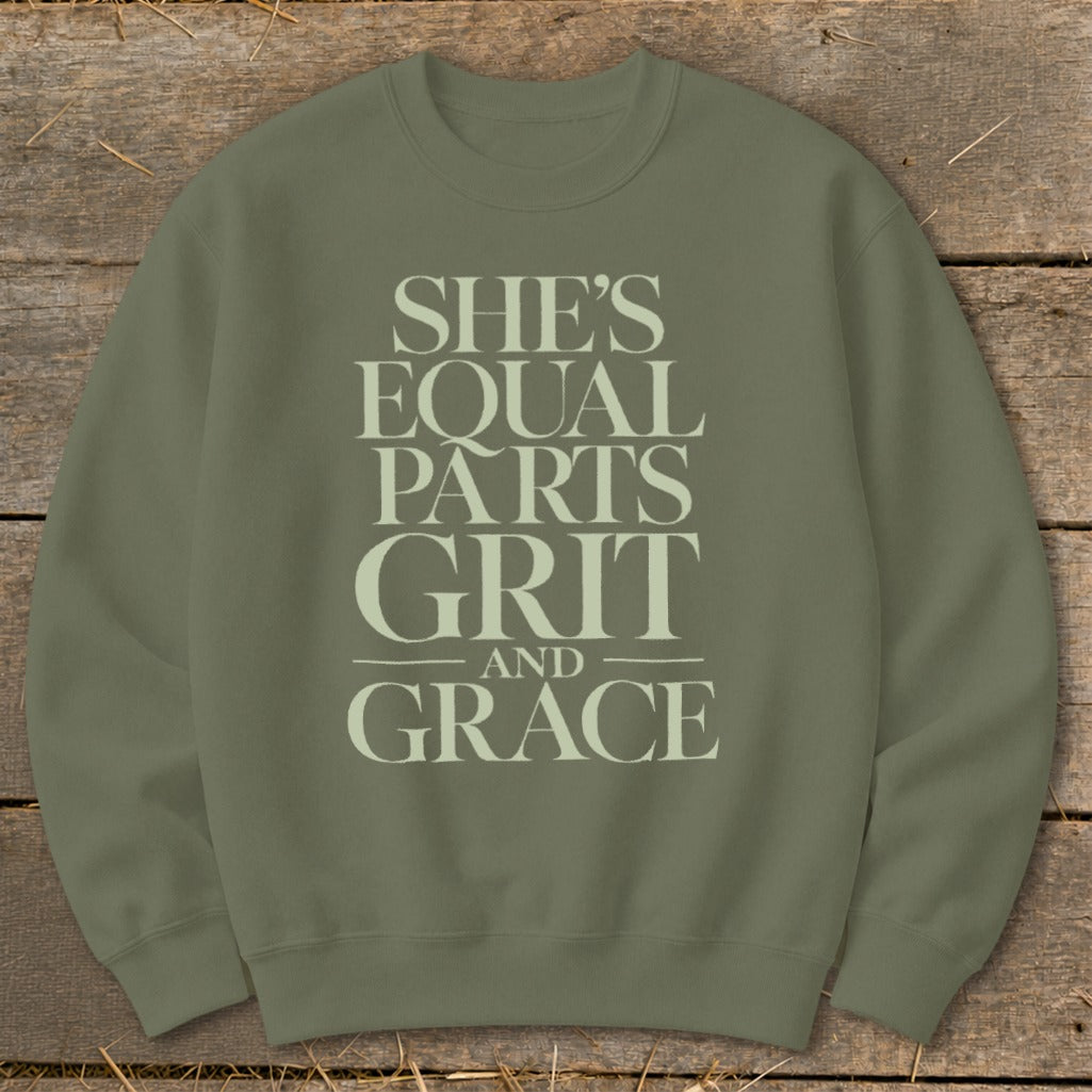 An olive green crewneck sweatshirt featuring the stacked text She's Equal Parts Grit And Grace.