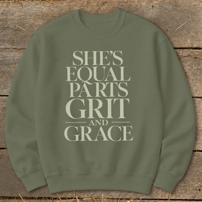 An olive green crewneck sweatshirt featuring the stacked text She's Equal Parts Grit And Grace.