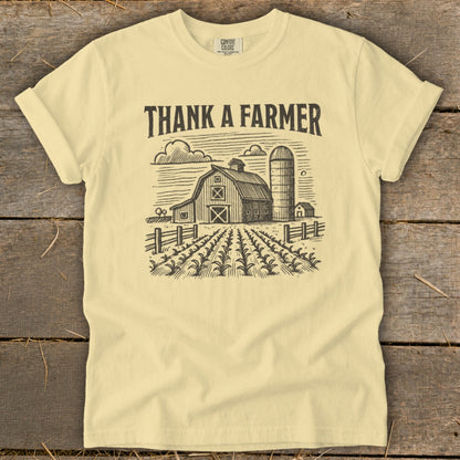 Light yellow t-shirt with "THANK A FARMER" text over a farm scene.