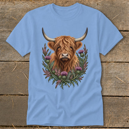 Light blue t-shirt with a Highland cow and thistles graphic design.