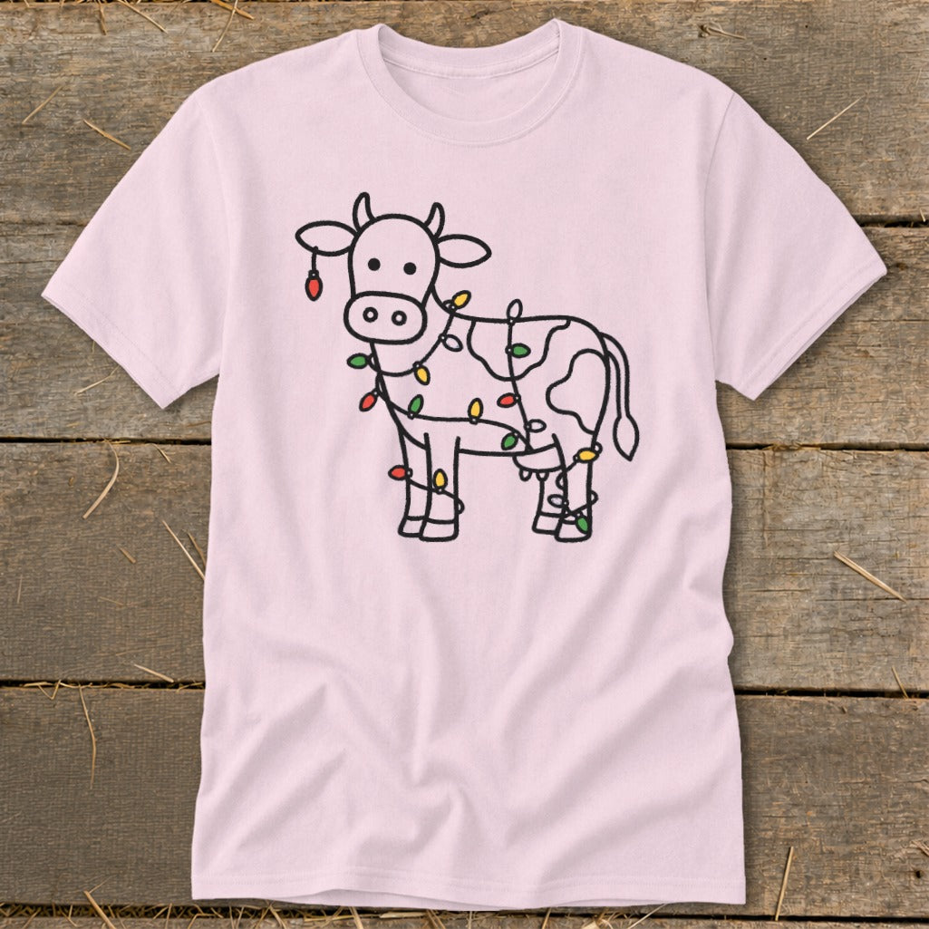 Pink t-shirt with a line drawing of a cow decorated with colorful Christmas lights.