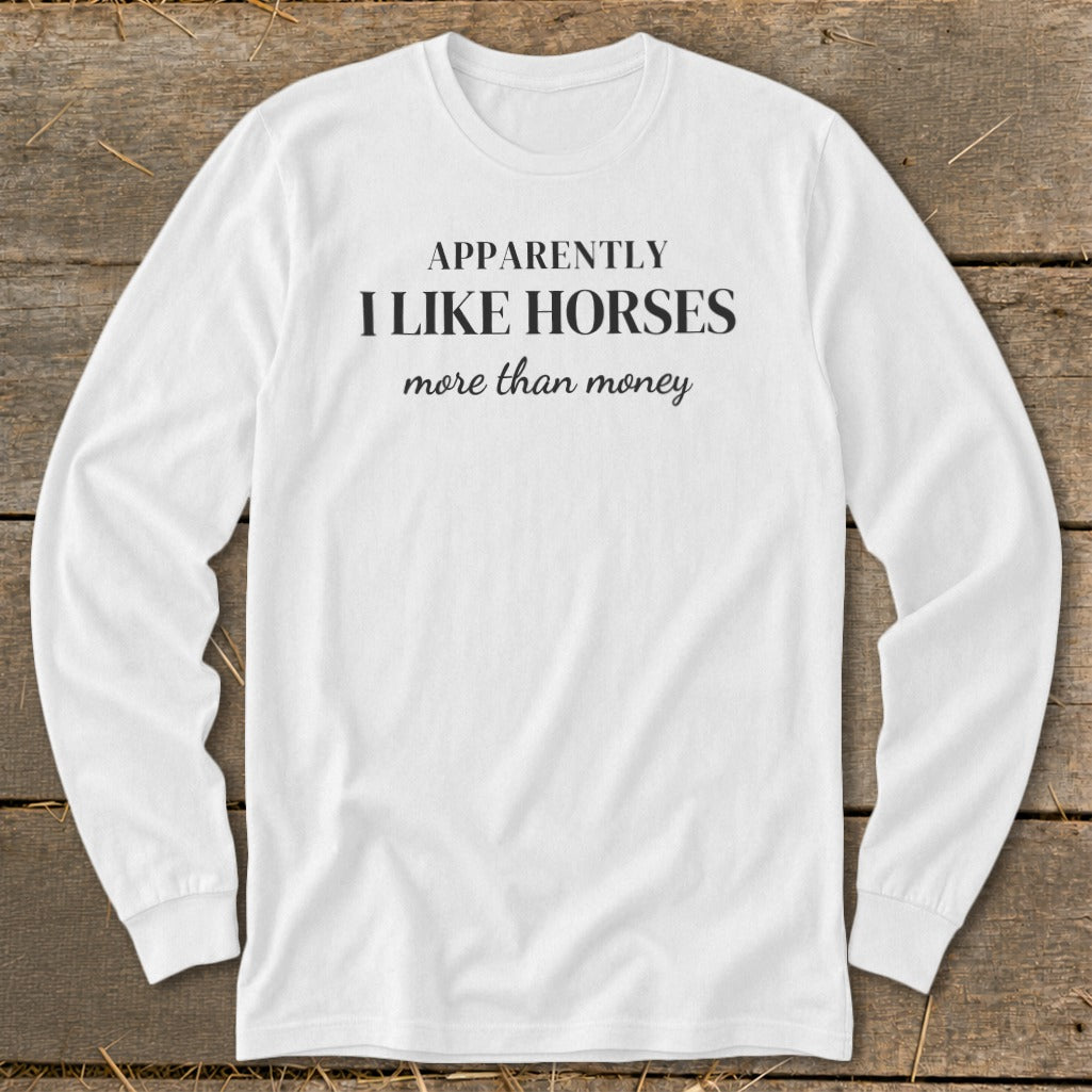 White long-sleeved shirt with "APPARENTLY I LIKE HORSES more than money" text.