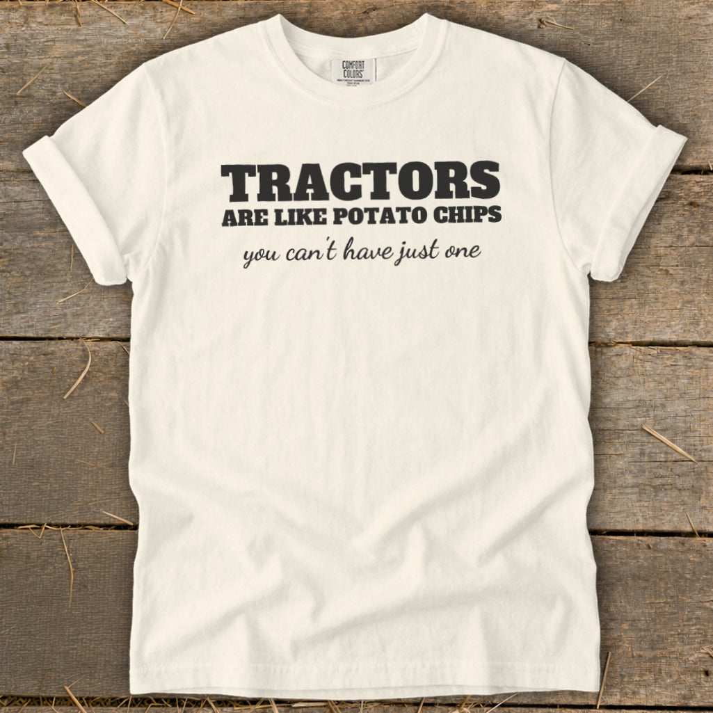 White t-shirt with black text reading "TRACTORS ARE LIKE POTATO CHIPS you can't have just one"