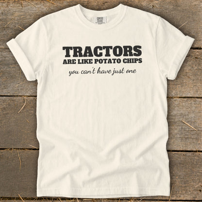 White t-shirt with black text reading "TRACTORS ARE LIKE POTATO CHIPS you can't have just one"