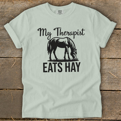 Light green t-shirt with black text "My Therapist Eats Hay" and a horse silhouette.