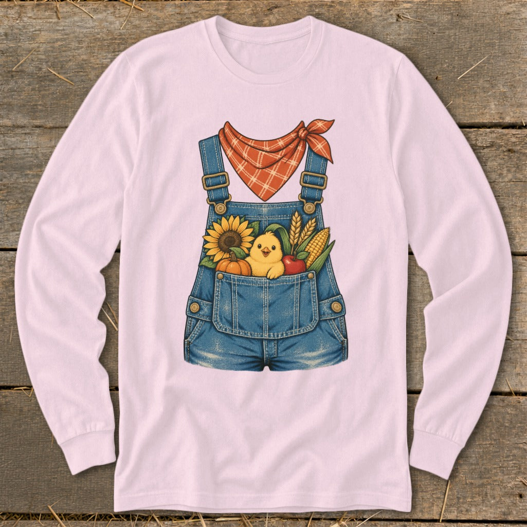 Pink long-sleeve shirt with a denim overalls graphic featuring a chick and fall harvest items.