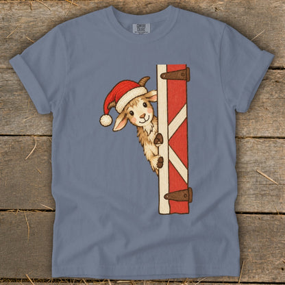 Goat wearing Santa hat peeking from behind a red and white barn door.