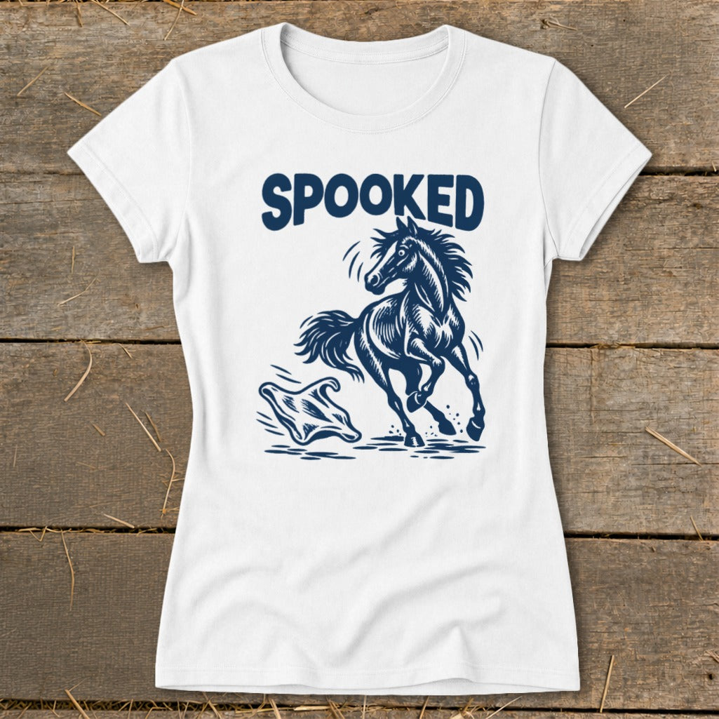 White t-shirt with dark blue "SPOOKED" text and a startled horse jumping over a ghost graphic.