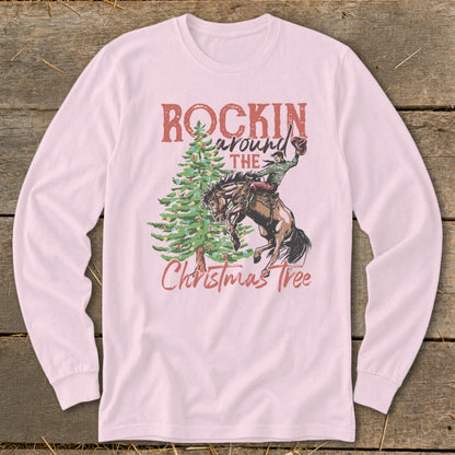Pink long sleeve shirt with "Rockin Around The Christmas Tree" and cowboy riding horse graphic.