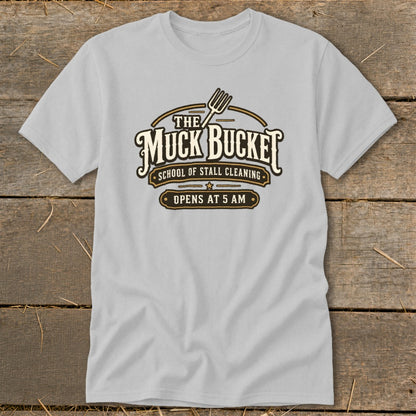 Light grey t-shirt with "The Muck Bucket School of Stall Cleaning" logo.