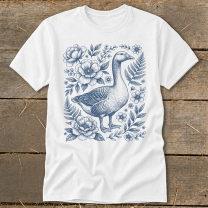 White t-shirt with a blue line drawing of a goose surrounded by flowers and ferns.