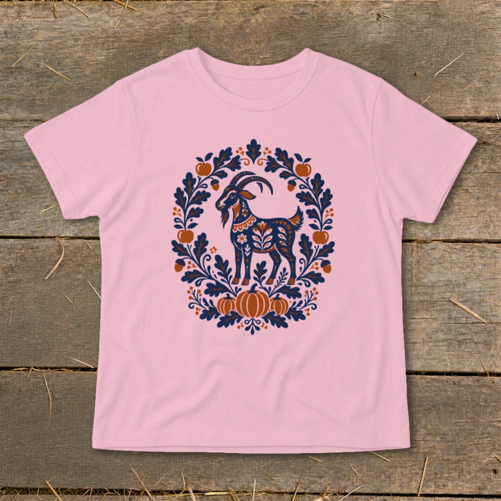 Light pink t-shirt featuring a folk art illustration of a goat surrounded by leaves and pumpkins.