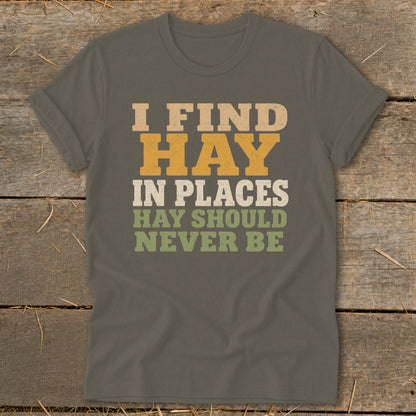 T-shirt with text "I FIND HAY IN PLACES HAY SHOULD NEVER BE" in vintage font.