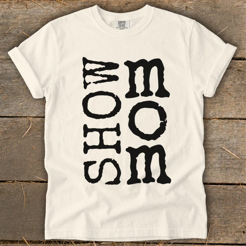 Cream t-shirt with black vertical text reading "MOM" and "SHOW"
