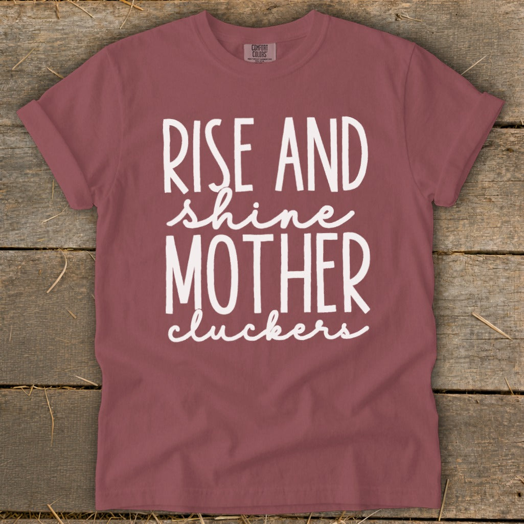 Maroon t-shirt with white text reading "RISE AND shine MOTHER cluckers".
