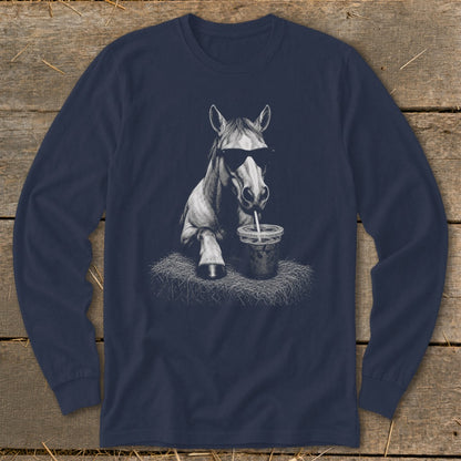 Horse wearing sunglasses drinks from a straw in a cup on a hay bale.