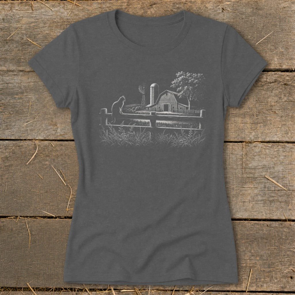 Gray t-shirt with a white line drawing of a cat on a fence in front of a farm scene.