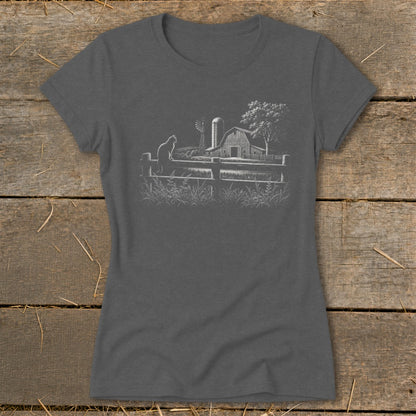 Gray t-shirt with a white line drawing of a cat on a fence in front of a farm scene.