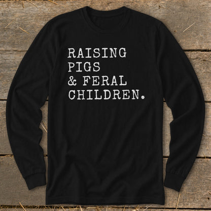 Black long-sleeve shirt with white text reading "RAISING PIGS & FERAL CHILDREN."